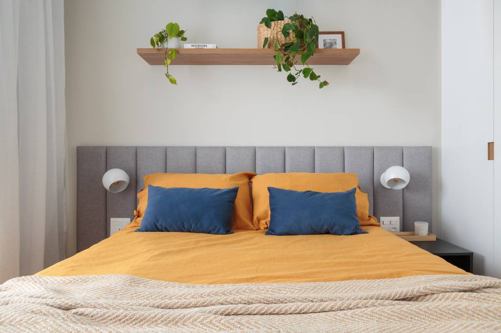 tons-azul-amarelo-ape-compacto-42m-estudio-mare-10-quarto Projeto de Estúdio Maré. Na foto, quarto com cabeceira estofada cinza e prateleira acima da cama.
