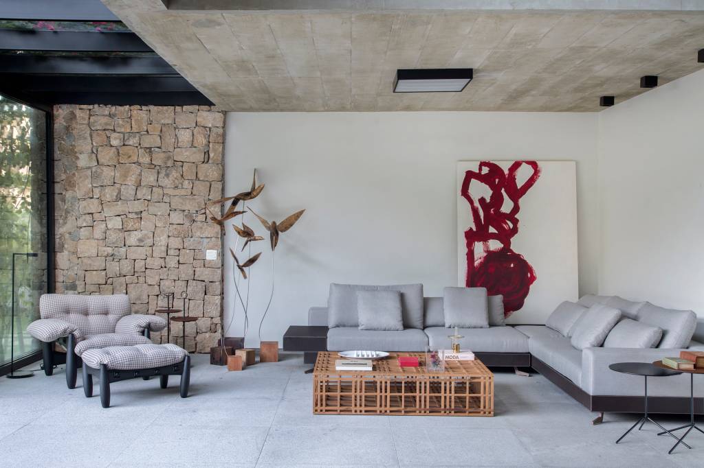 varanda-residencia-511-m2-dentro-casa-sabugosa-arquitetura-credito-mca-estudio (6) A varanda desta residência de 511 m² fica dentro de casa. Projeto Sabugosa Arquitetura. Sala de estar integrada ao jardim com parede de pedra, poltrona mole e sofá em l.