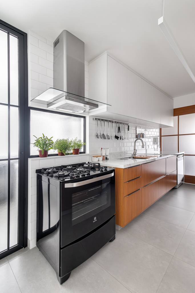 cozinha-minimalista-pensada-abrigar-utensilios-inovando-arquitetura-05 Cozinha minimalista foi pensada para abrigar muitos utensílios. Projeto de Inovando Arquitetura. Na foto, cozinha com porta de vidro para cozinha e armários brancos e madeira.