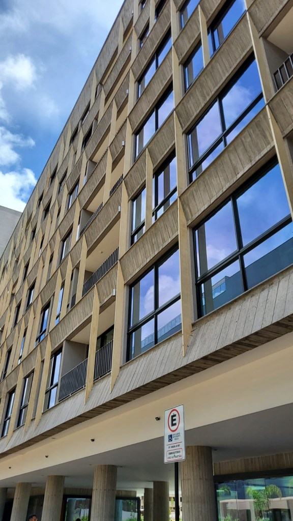 Veja 3 projetos que trazem um olhar contemporâneo sobre elementos modernos. Na foto, prédio com fachada com brises decorativos de madeira.
