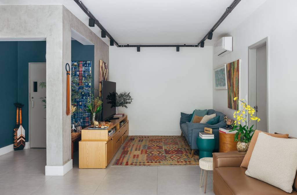 ape-140-m2-parece-casa-meio-arvores-ana-cano-credito-luiza-schreier (1) Apartamento de 140 m² parece uma casa em meio às árvores. Projeto Ana Cano. Na foto, sala de estar com tv, trilhos e tapete.