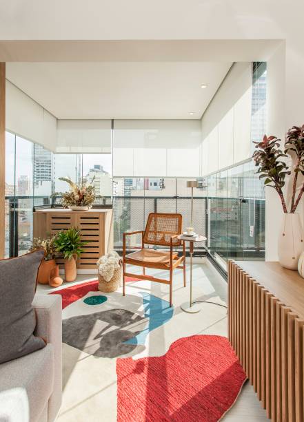 Uma das primeiras intervenções feita pela arquiteta Carina Dal Fabbro neste apartamento foi a retirada da esquadria que separava a sala da varanda, melhorando a circulação. Outra solução foi ocultar a condensadora do ar-condicionado numa caixa ripada, com a mesma madeira do rack. Uma das primeiras intervenções feita pela arquiteta Carina Dal Fabbro neste apartamento foi a retirada da esquadria que separava a sala da varanda, melhorando a circulação. Outra solução foi ocultar a condensadora do ar-condicionado numa caixa ripada, com a mesma madeira do rack.