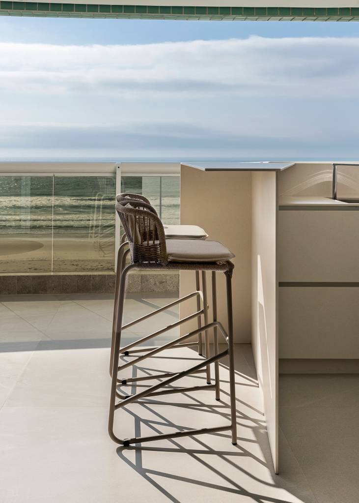 varanda-generosa-vista-para-o-mar-ape-160m-sum-studio-03 Varanda generosa com vista para o mar é destaque em apê de 160m². Projeto de SUM + Studio. Na foto, varanda com bancada de churrasqueira.