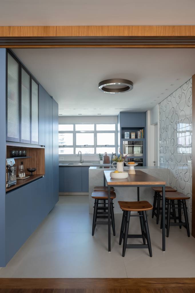 apartamento-188-m2-dois-cooktops-cozinha-balancos-sala-raizes-arquitetos-credito-guilherme-pucci (4) Apartamento de 188 m² ganha dois cooktops na cozinha e balanços na sala, Projeto Raízes Arquitetos. Na foto, cozinha com marcenaria azul e ilha. Cooktop e nicho para café.