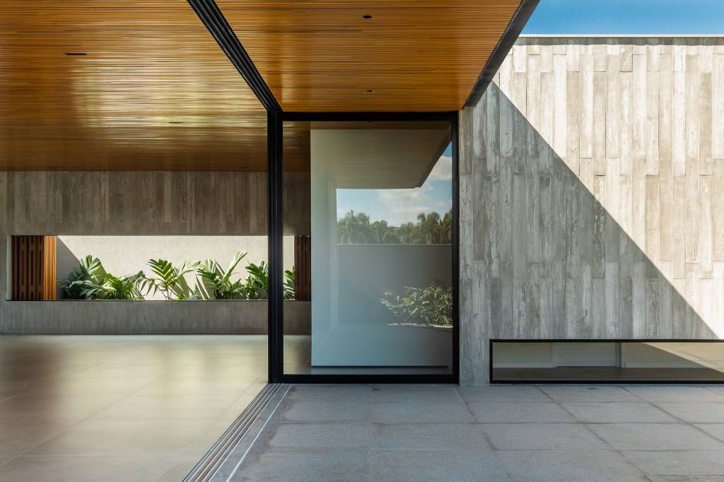 casa-379-m2-arquitetura-minimalista-integracao-entorno-camila-porto-credito-israel-gollino (10) Casa de 379 m² une arquitetura minimalista e integração com o entorno. Projeto Camila Porto. Na foto, varanda gourmet com vista para o jardim.