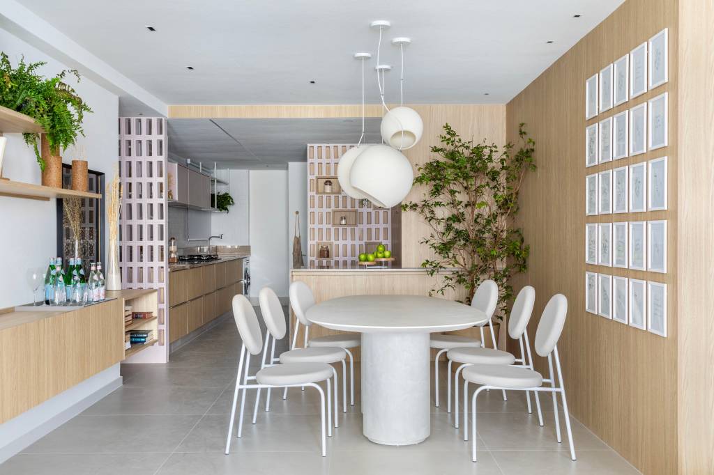Japandi: apê de 110 m² tem décor delicado em tons de branco, rosa e cinza. Projeto de Up3 Arquitetura. Na foto, sala de jantar com mesa e cadeiras brancas, luminária branca.