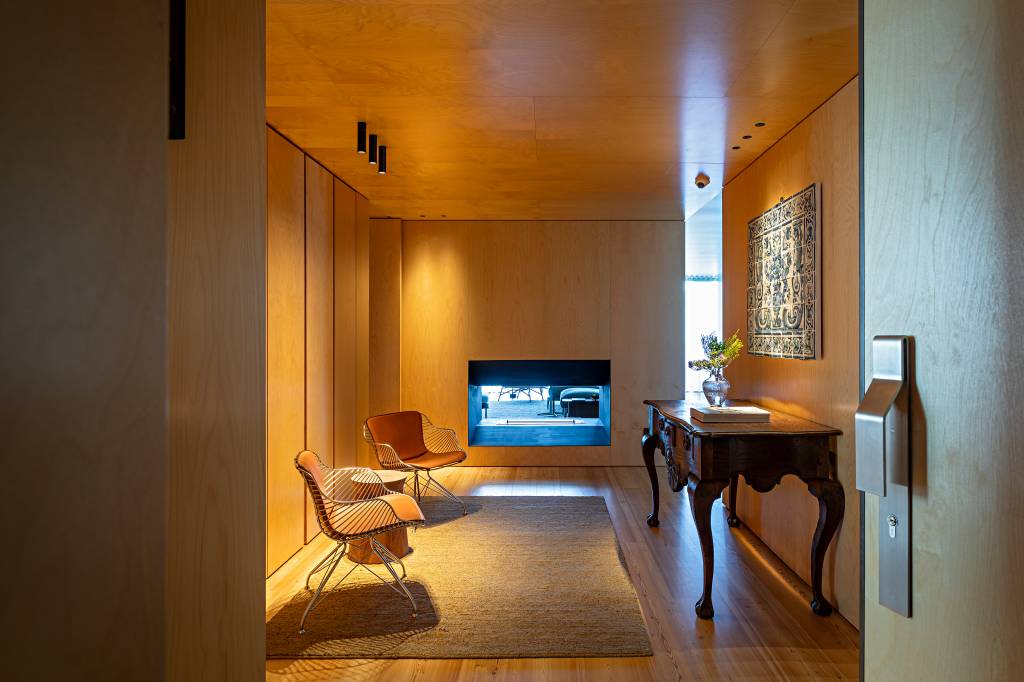 mix-antigo-moderno-diferentes-culturas-ape-290-m-andrea-chicharo-12 Mix entre antigo e moderno com diferentes cultuaras define apê de 290 m². Projeto de Andrea Chicharo Arquitetura. Na foto, sala revestida de madeira com poltronas e lareira.
