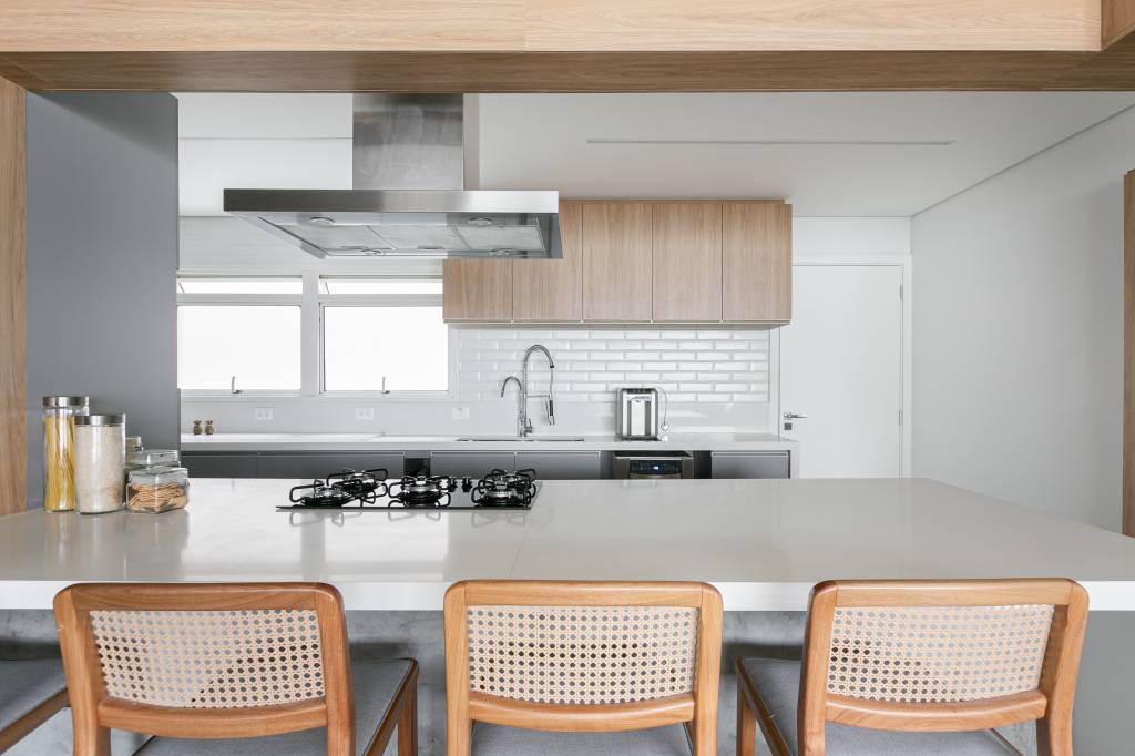 paineis-madeira-escondem-cozinha-home-office-apartamento-atelier-c2ha-credito-gisele-rampazzo (6) Painéis de madeira escondem a cozinha e home office deste apartamento. Projeto do atelier C2H.a. Na foto, cozinha com marcenaria cinza e tiles brancos.