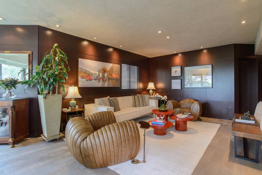 paineis-madeira-escura-ape-250-m2-andrea-parreira-credito-edson-ferreira (8) Painéis de madeira escura caracterizam o projeto deste apê de 250 m². Projeto de Andrea Parreira Arquitetura. Na foto, sala de estar com parede de madeira, poltronas e mesa de centro vermelha.