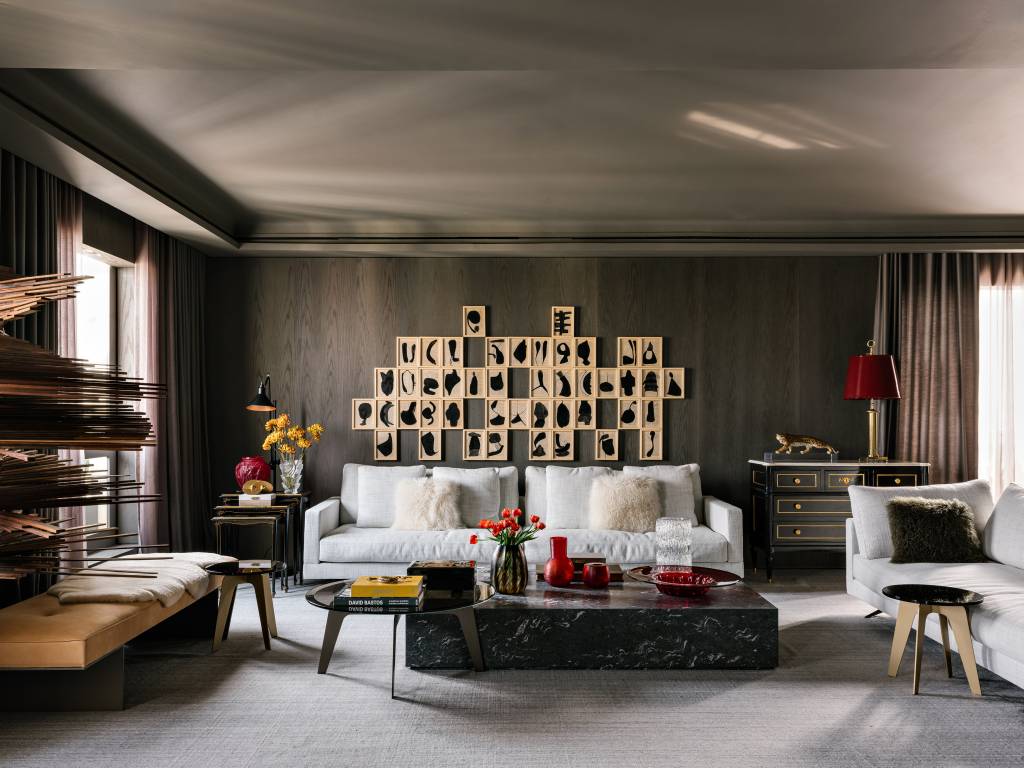 Piso de mármore e parede com painéis escuros dão elegância sóbria a apê