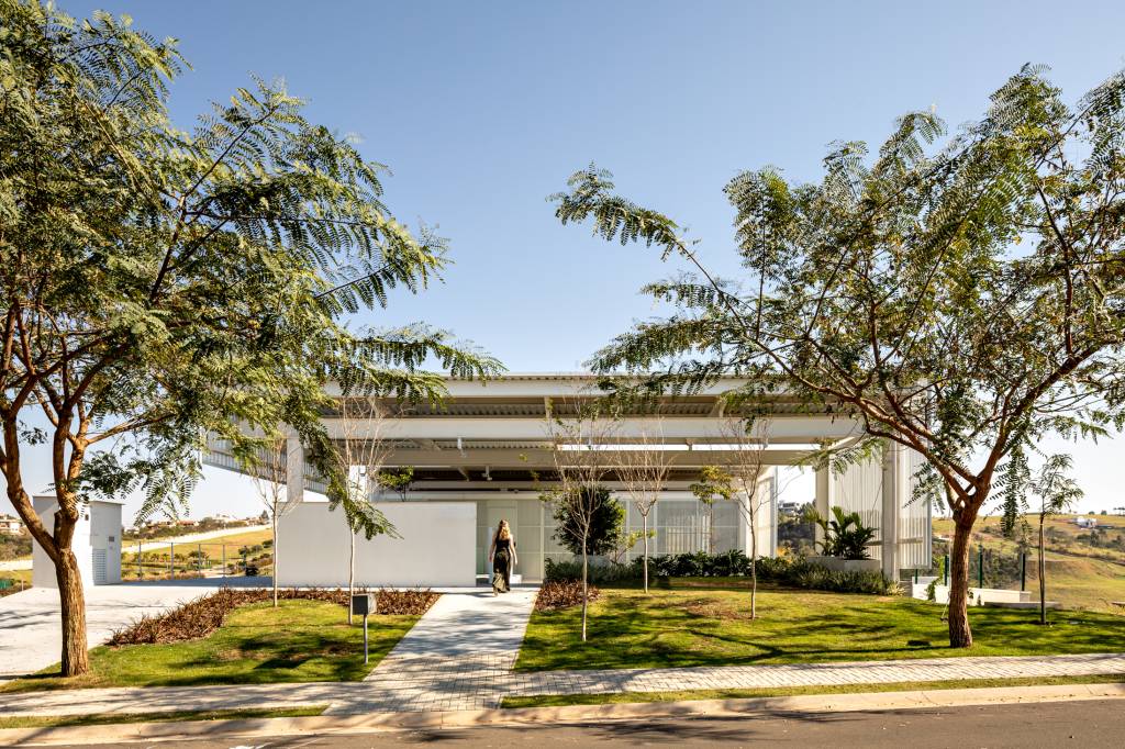 Treliças brancas de metal compõem a fachada desta casa em Campinas. Projeto de FGMF. Na foto, fachada com jardim.