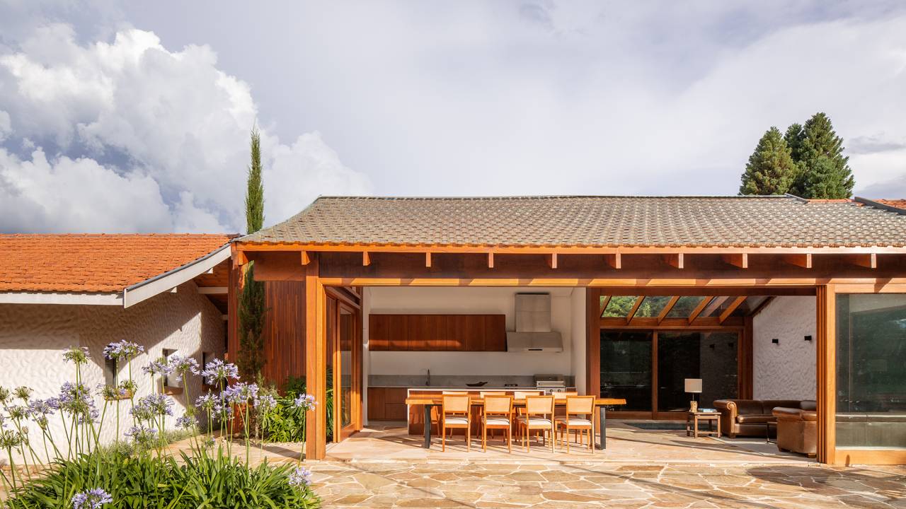 Anexo de 190m ² renova antiga casa em Campos do Jordão. Projeto Vaga Arquitetura. Na foto, varanda com espaço gourmet e estar.