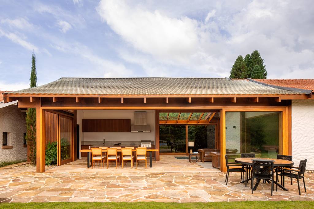 anexo-190-m2-renova-antiga-casa-campos-jordao-vaga-arquitetura-credito-carolina-lacaz (13) Anexo de 190m ² renova antiga casa em Campos do Jordão. Projeto Vaga Arquitetura. Na foto, varanda com espaço gourmet, jardim e estar.