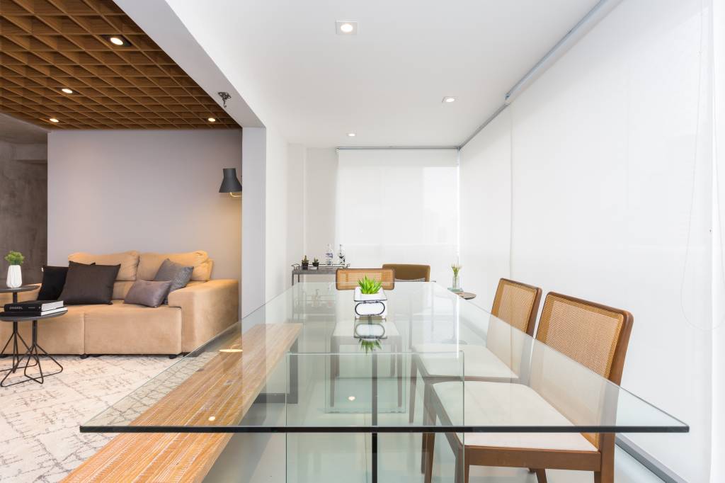 ape-89-m-paredes-cimento-queimado-piso-com-camada-de-epoxi-ju-matos-05-varanda Apê de 89 m² ganha paredes com cimento queimado e piso com camada de epóxi. Projeto de Ju Matos. Na foto, varanda integrada com persianas brancas, mesa de vidro.