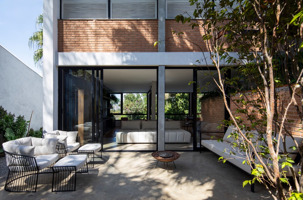 Casa dos anos 1950 ganha novo projeto que preserva a arquitetura original, Projeto de Conrado Ceravolo. Na foto, varanda com espaço de estar e jardim.