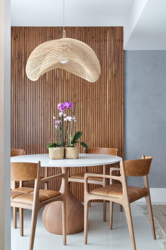 couro-madeira-fibra-decor-contemporaneo-cobertura-130-m-travessa-arquitetura-04-jantar-rattan Couro, madeira e fibra compõem décor contemporâneo de cobertura de 130 m². Projeto de Travessa Arquitetura. Na foto, sala de jantar, parede ripada, mesa redonda branca, cadeira de madeira e couro, luminária de rattan.