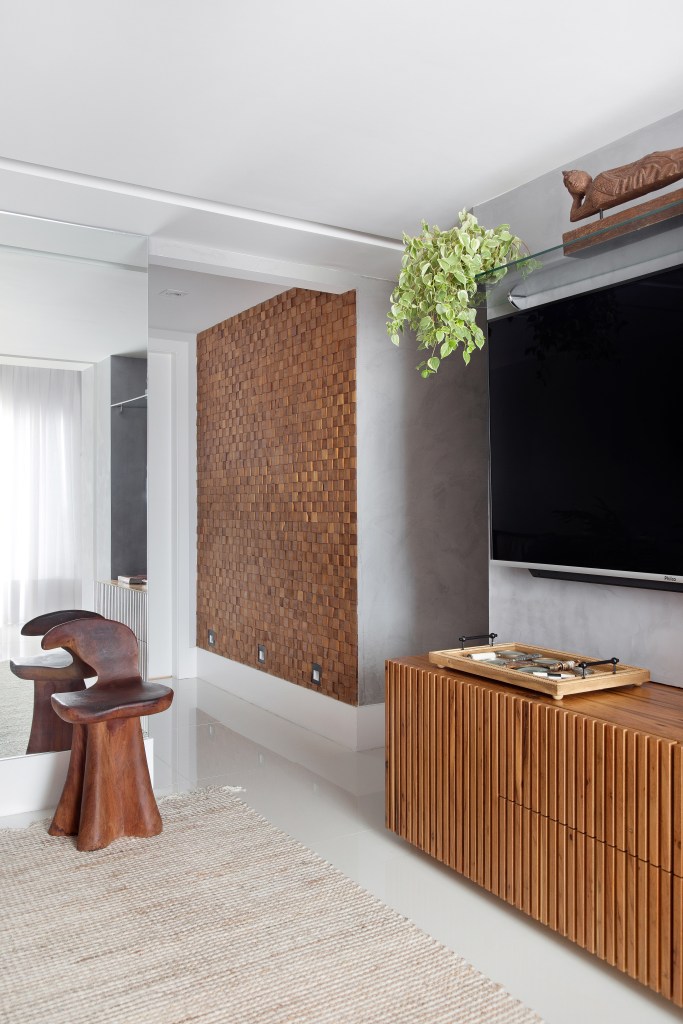 Couro, madeira e fibra compõem décor contemporâneo de cobertura de 130 m². Projeto de Travessa Arquitetura. Na foto, sala de estar, rack, tv.
