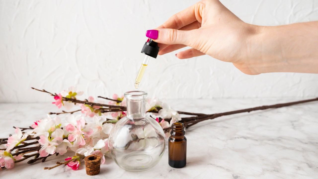 Florais: afaste medo, indecisão, solidão com essas combinações. Na foto, mesa com frasco de vidro e mão pingando floral.