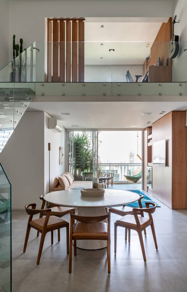 Apartamento de 170 m² com pé-direito duplo tem estúdio de DJ no mezanino. Projeto de Carolina Esper. Na foto, sala com pé-direito duplo e mesa de jantar.