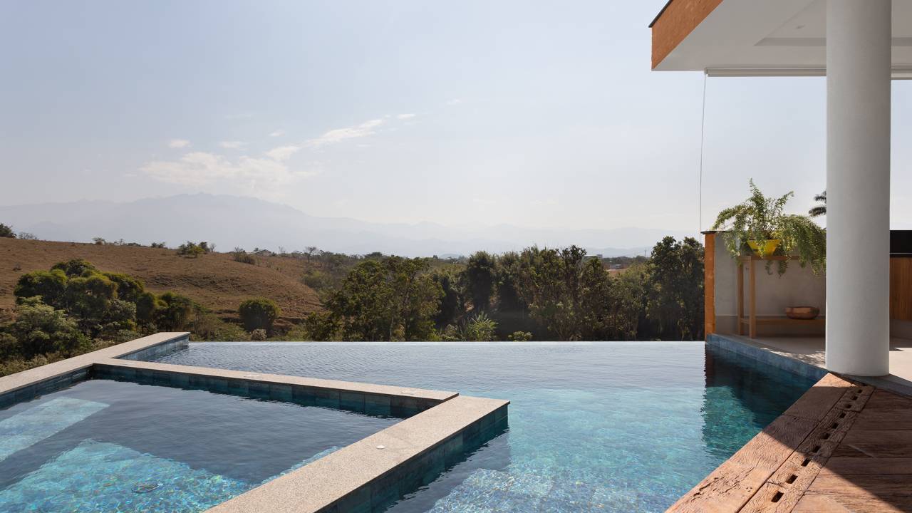 Casa de 435 m² com vista para a Serra possui piscina em formato diagonal. Projeto de Vivi Cirello. Na foto, piscina com vista para a serra.