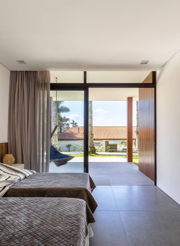 casa-composta-por-tres-volumes-ligados-por-pergolado-de-madeira-arkitito-23 Casa é composta por três volumes ligados por pergolado de madeira. Projeto de Arkitito. Na foto, quarto, grande janela.