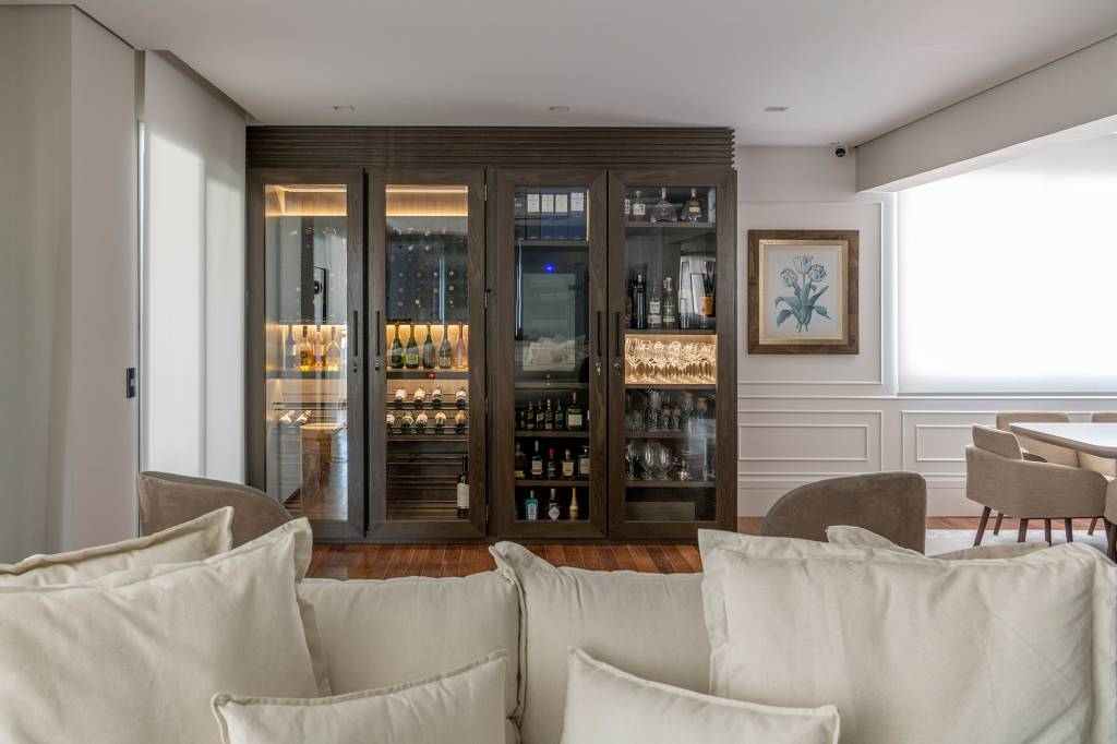 Madeira escura e vista para skyline trazem elegância para apê de 280 m²