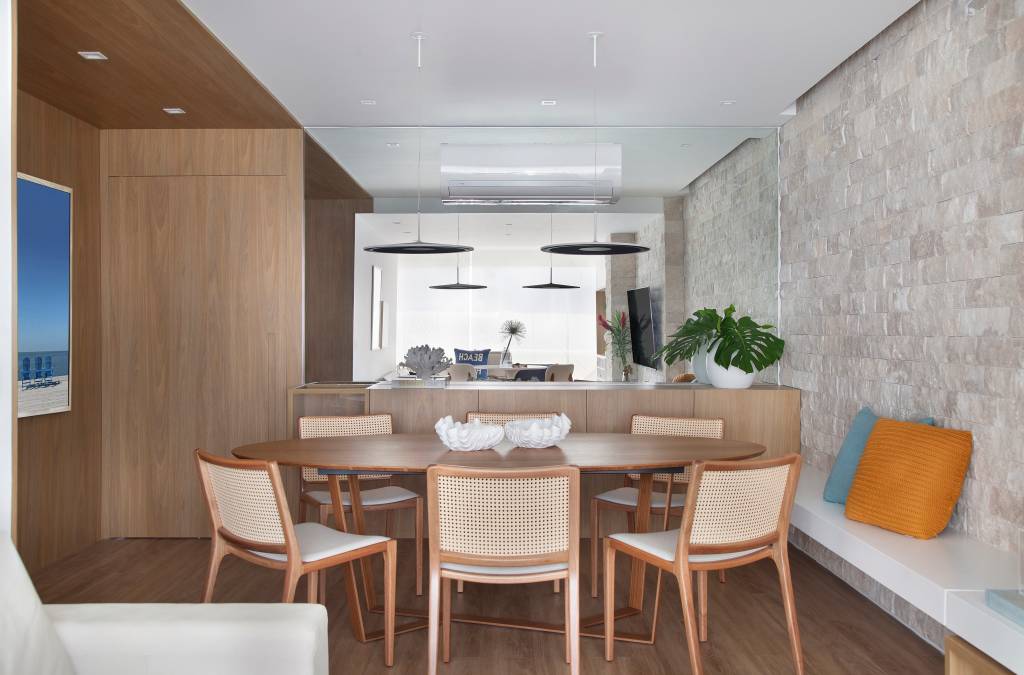 canto-alemao-varanda-local-cafe-manha-ape-memoa-arquitetos-02-sala Canto alemão na varanda cria local perfeito para café da manhã em apê. Projeto de Memoá Arquitetos. Na foto, sala de jantar com mesa de jantar oval, piso de madeira, espelho, paredes revestidas com painéis de madera.
