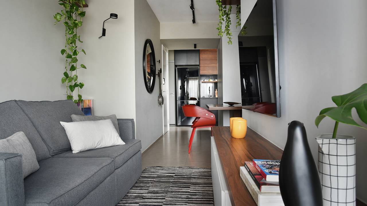 Com apenas 56 m², apartamento ganha décor jovem e descolado. Projeto de Flavia Campos e Sandra Paes. Na foto, sala de estar com TV, jantar integrado e sofá cinza.