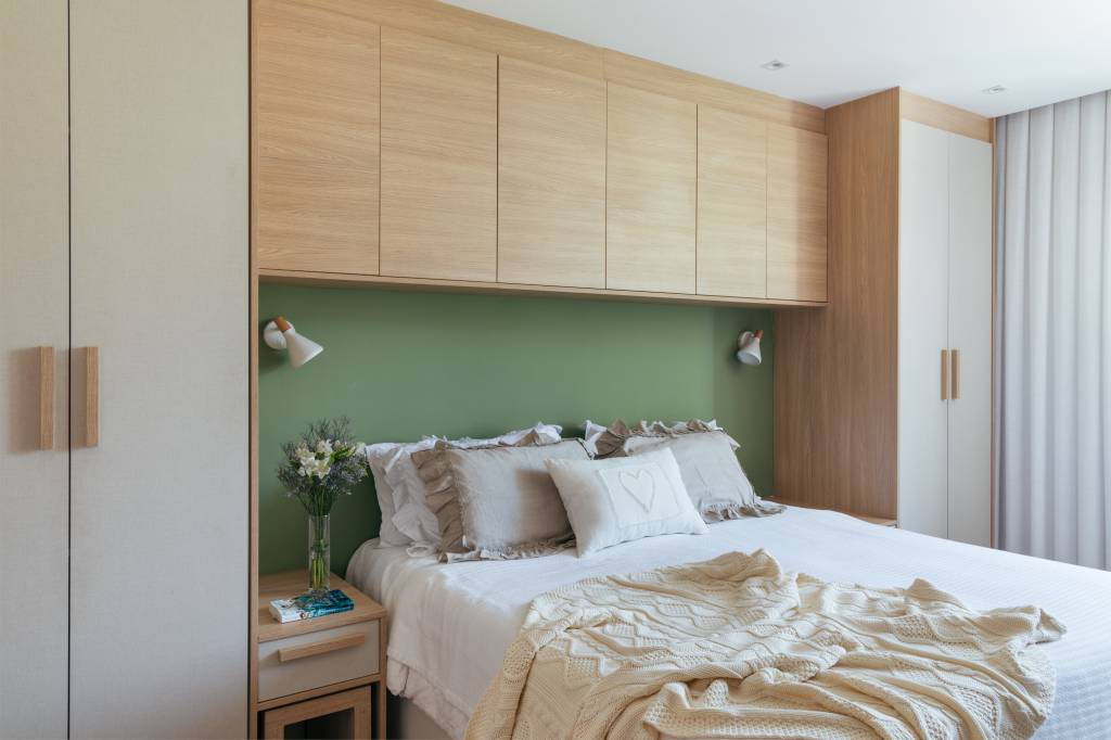 dois-apes-viram-um-cozinha-gourmet-jantar-sala-de-tv-integradas-fernanda-medeiros-12-quarto-verde Dois apês viram um com cozinha gourmet, jantar e sala de TV integradas. Projeto de Fernanda Medeiros. Na foto, quarto de casal, marcenaria personalizada contornando a cama, parede verde.