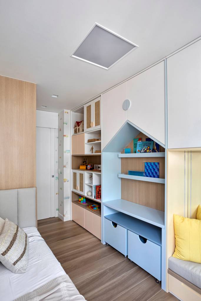espelho-atras-sofa-amplia-ape-70-m-paleta-de-cores-clara-fpr-studio-12-quarto-infantil Espelho atrás do sofá amplia apê de 70 m² com paleta de cores clara. Projeto de FPR Studio. Na foto, quarto infantil com estante de marcenaria em formato de casinha.