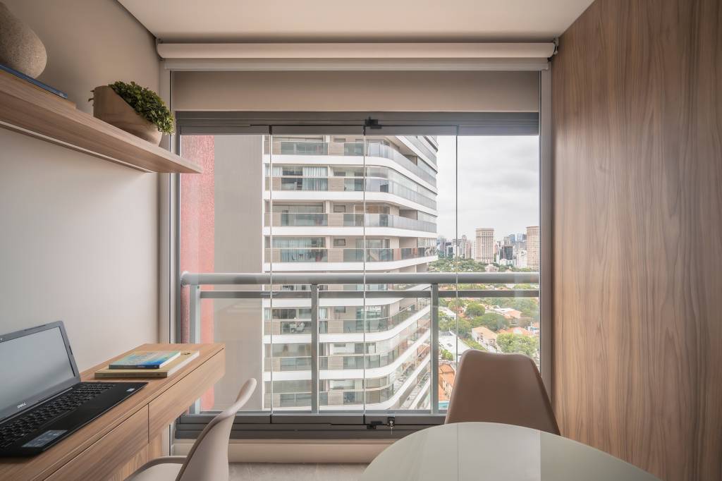 varanda-envidracada-otimiza-area-apartamento-24-m2-gabriela-campanha-credito-henrique-ribeiro (11) Varanda envidraçada otimiza a área de apartamento de apenas 24 m². Projeto de Gabriela Campanha. Na foto, home office na varanda fechada com vidro.