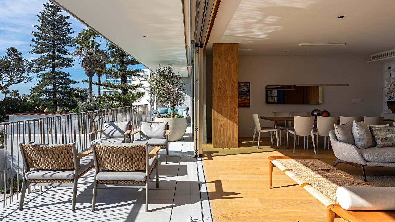 Apartamento Estoril, em Portugal, ganha décor com brasilidade. Projeto de Andrea Chicharo. Na foto, varanda ampla, porta de trilho de correr, poltronas na área externa.