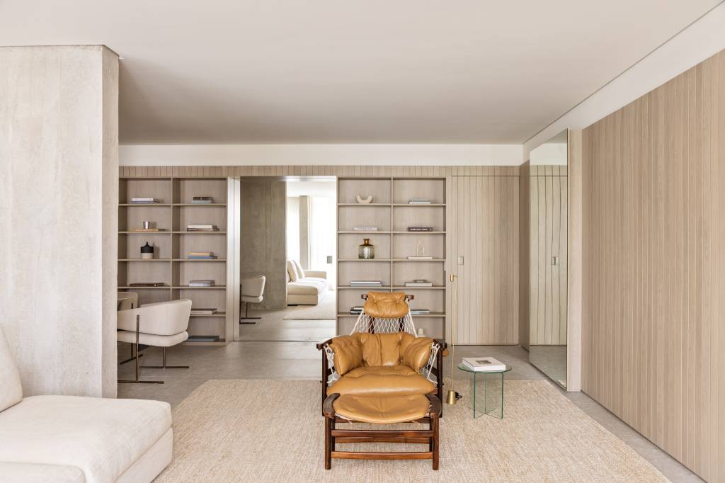 marcenaria-setoriza-decora-apartamento-156-m2-alexandre-dal-fabbro-credito-evelyn-muller (19) Marcenaria setoriza e decora apartamento de 156 m². Projeto de Alexandre Dal Fabbro. Na foto, sala de estar com paredes ripadas, poltrona e tapete.