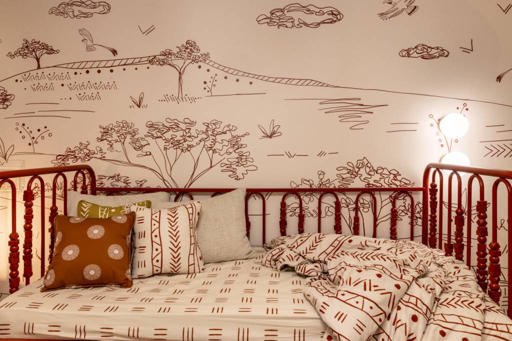 quarto-bebe-25-m2-homenageia-rainha-angola-njinga-kesley-santiago-credito-bia-nauiack (10) Quarto de bebê de 25 m² homenageia a rainha de Angola, Njinga. Projeto de Kesley Santiago para a CASACOR São Paulo 2024. Na foto, berço com estrutura vermelha e papel de parede estampado.