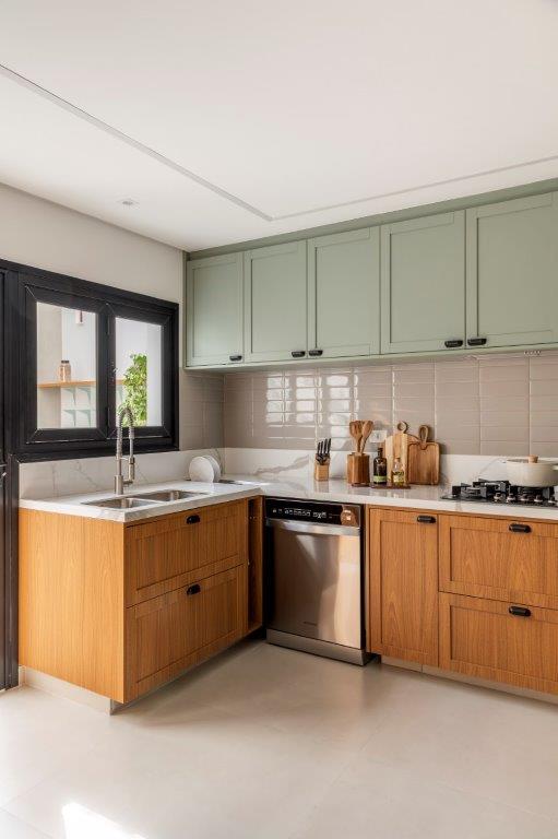 Casa de 146 m² ganha cozinha verde clara e área externa com churrasqueira. Projeto de Camila Bischoff. Na foto, cozinha em estilo provençal, armários verdes, bancada branca, backsplash de tijolinhos.