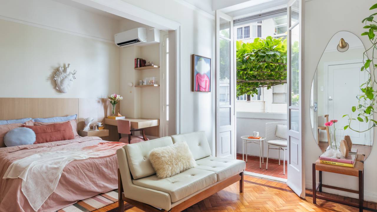 Apê de 42 m² em tons de branco e bege tem sala e quarto integrados. Projeto de Rodolfo Consoli. Na foto, sofá pequeno, porta de correr, varnada.