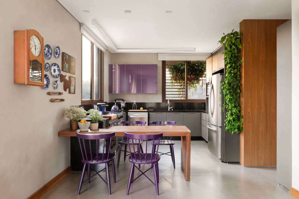casa-de-campo-lareira-sofa-cozinhas-roxos-camila-medrado-16-jardim-vertical Sintonia com natureza: casa de campo com lareira tem sofá e cozinhas roxos. Projeto de Camila Medrado. Na foto, cozinha com cadeira, mesa de madeira, jardim vertical, bancada preta.