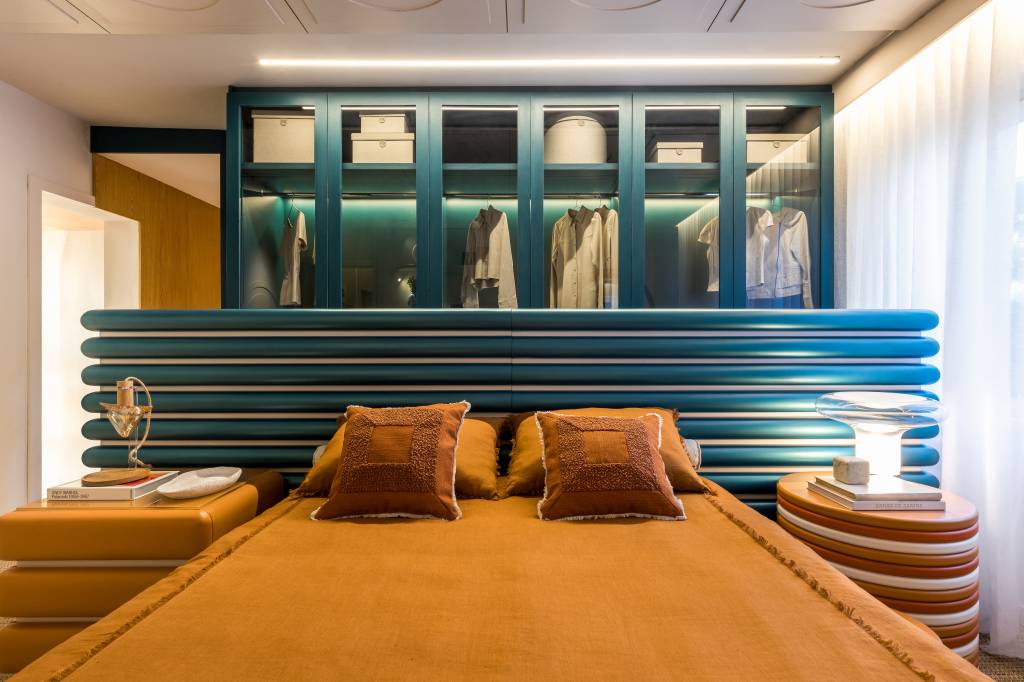 Cabeceira azul é divisória entre quarto e closet inspirados nos anos 1980