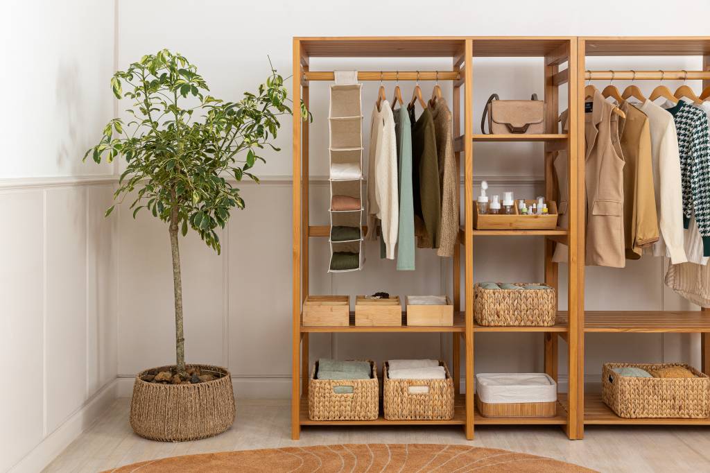 4 lemas para mantar a casa sempre organizada. Na foto, armário de madeira, closet aberto organizado, planta.