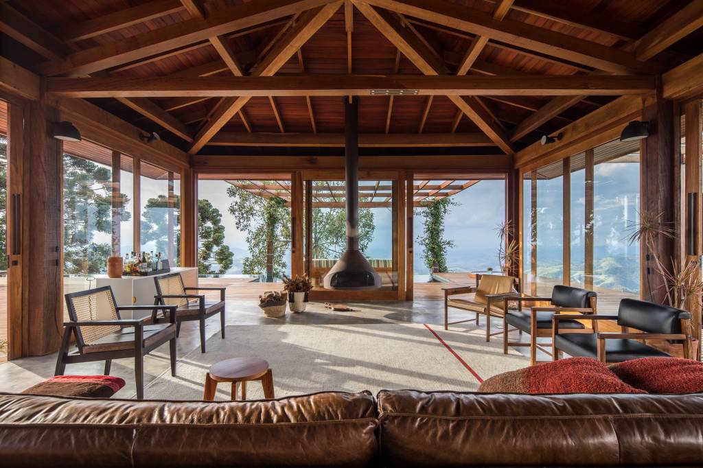 Linda casa na montanha tem lareira e cozinha rústica com fogão à lenha