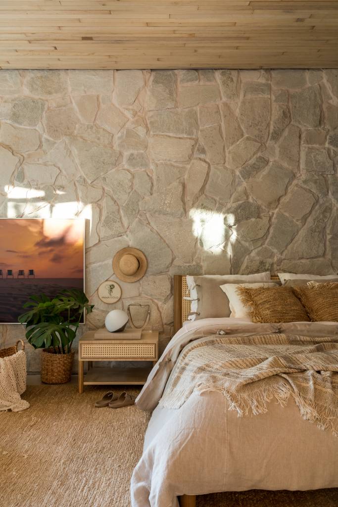 pedras-e-vegetacao-em-abundancia-marcam-a-estetica-organica-deste-loft-maria-alice-crippa-gustavo-assis-06-quarto-parede-pedra Pedras e vegetação em abundância marcam a estética orgânica deste loft. Projeto de Maria Alice Crippa e Gustavo Assis. Na foto, suíte com parede de pedra