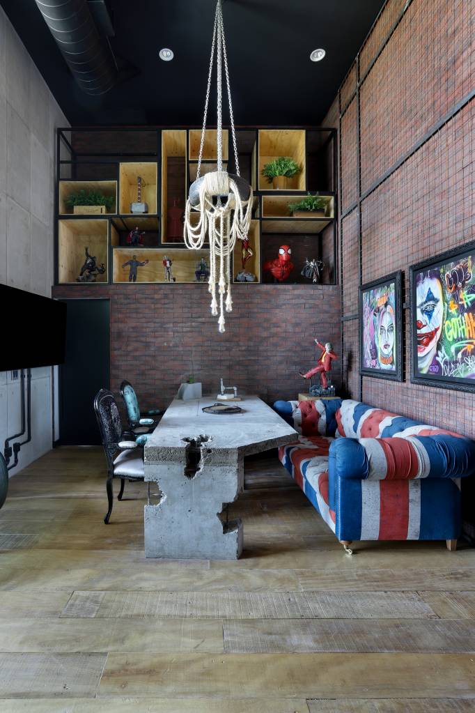 Tijolinhos e serralheria dão toque pop e industrial à apê de 163 m². Projeto de Studio Elã. Na foto, sala de jantar, mesa de concreto, sofá com estampa da bandeira da Inglaterra.