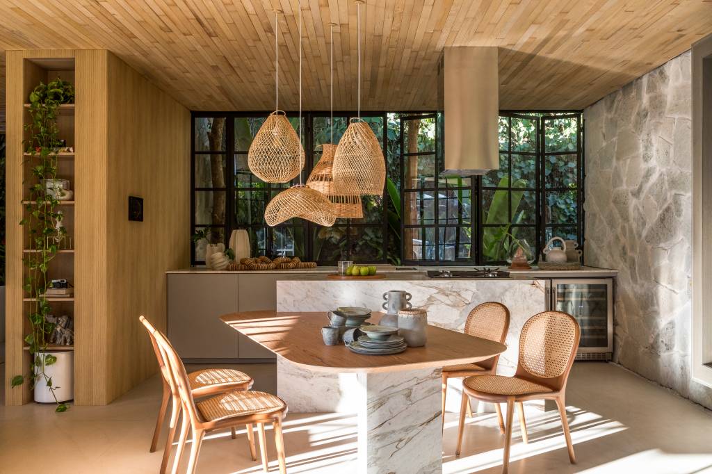 tiny-houses-discutem-sustentabilidade-relacao-com-natureza-casacor-pr-crippa-e-assis-arquitetura-06 3 tiny houses lindas que discutem sustentabilidade e a relação com a natureza. Projeto de Crippa e Assis para a CASACOR PR 2024. Na foto, sala de jantar integrada com cozinha, luminária de palhinha.