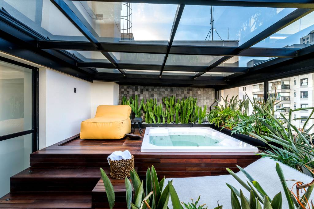 Apê preto e branco tem cobertura retrátil em vidro que abriga jacuzzi
