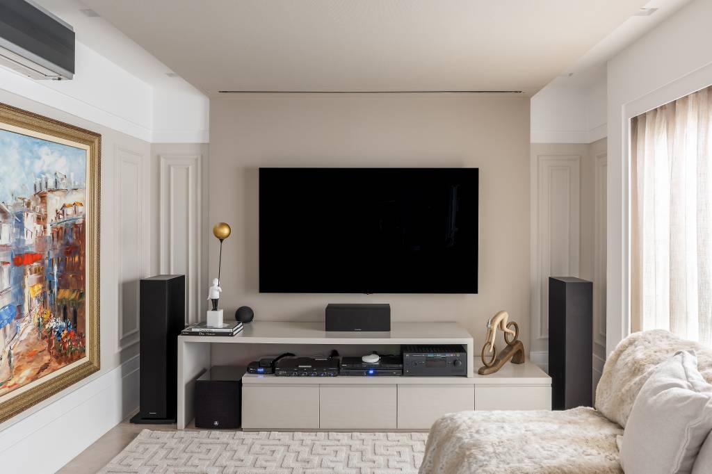 boiseries-como-elemento-classico-tornou-tendencia-cristiane-schiavoni-06-sala Boiseries: veja como o elemento clássico se tornou uma tendência contemporânea. Projeto de Cristiane Schiavoni. Na foto, sala de tv, rack, tapete branco, sofá branco.