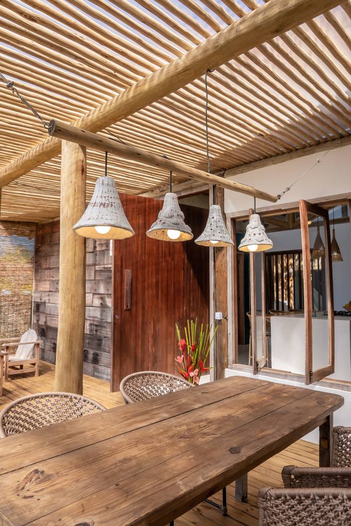 Casa pátio de praia na Bahia foi erguida em torno das árvores. Projeto de Mari Grobério. Na foto, varanda rústica.