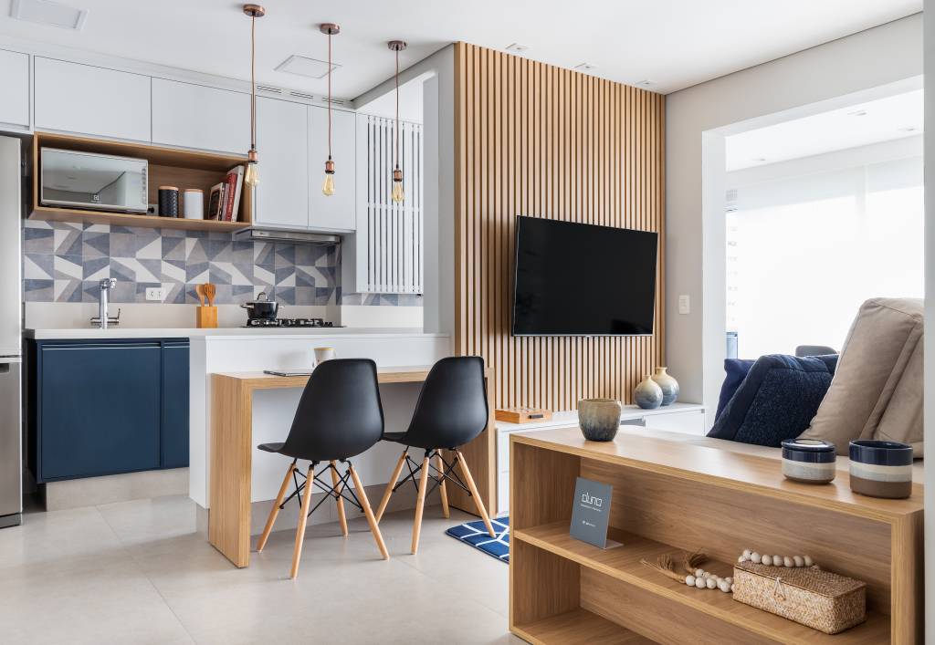 Cozinha com gabinete azul e painel ripado na sala dão textura e cor a apê de 62 m²