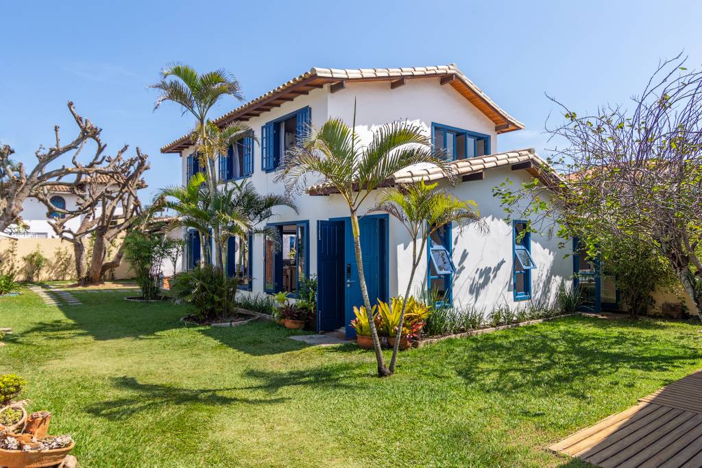Janelas azuis dão charme a casa de praia em Búzios com suíte térrea escondida por lambris