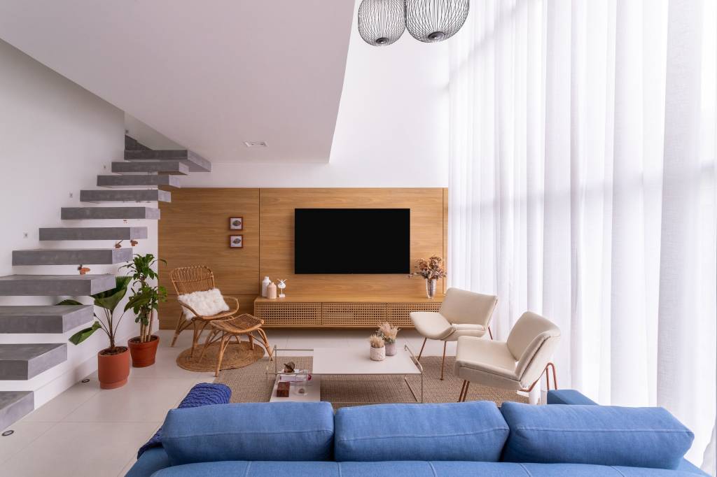 pergolado-bambu-abriga-area-descanso-futon-ofuro-casa-livia-quintella-06-sala Pergolado de bambu abriga área de descanso com futon e ofurô nesta casa. Projeto de Lívia Quintella. Na foto, sala de estar, sofá azul, escada, painel de madeira, cortina.