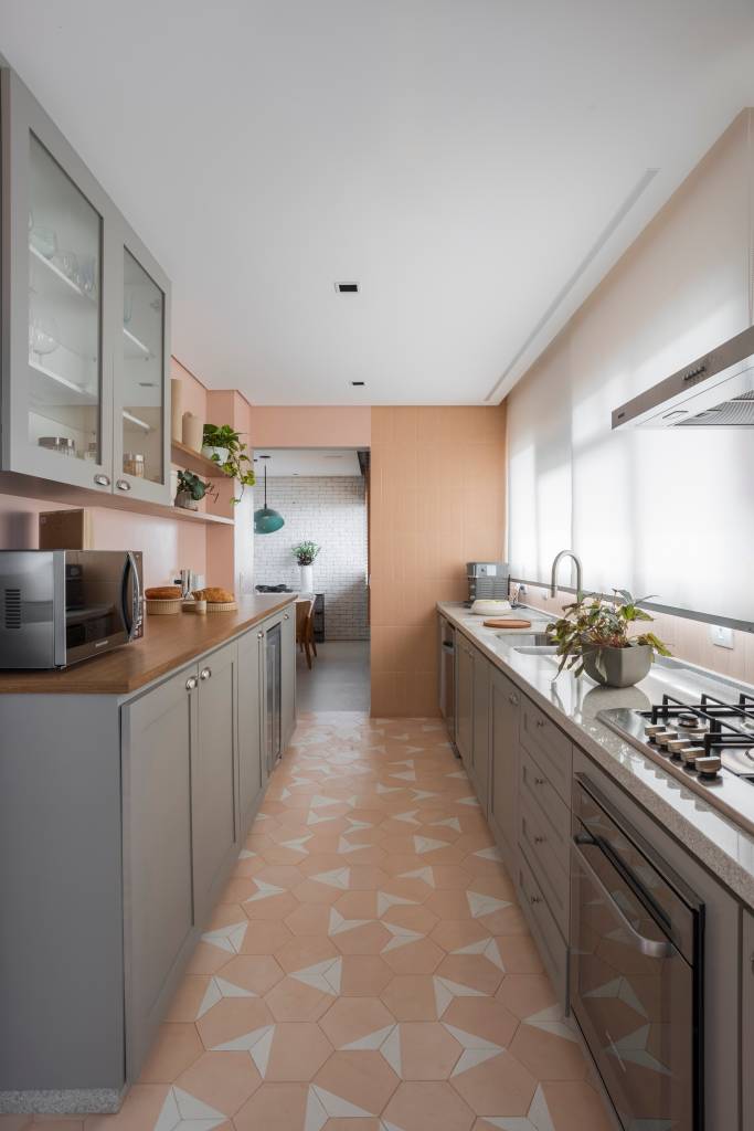 Reforma transforma quarto em home office e o integra a sala com porta de correr verde. Projeto de Adriana Favaro Arquitetura. Na foto, cozinha, armários cinzas, ladrilhos hidráulicos.